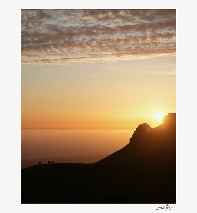 Golden sunset over fog-covered hills
