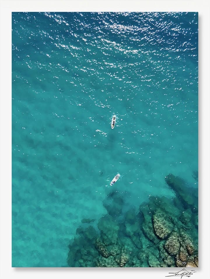 Aerial view of turquoise ocean with boats